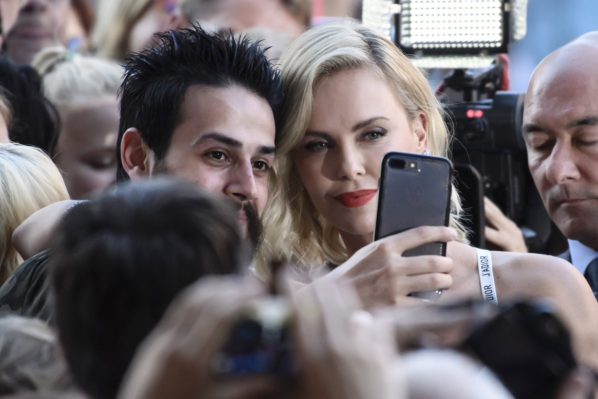 epa06093339 South African actress and cast member Charlize Theron (R) takes selfies with fans during the film premiere of 'Atomic Blonde' at the Theater am Potsdamer Platz in Berlin, Germany, 17 July 2017. The movie opens across German theaters on 24 August. EPA/CLEMENS BILAN